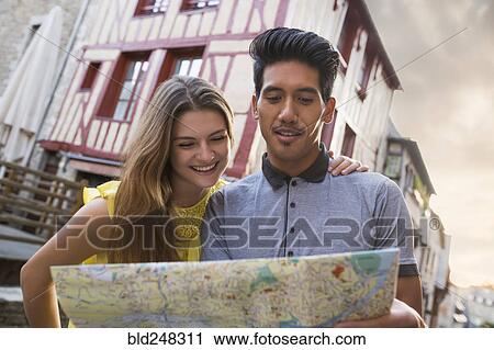 Stock Image - Couple reading map in city. Fotosearch