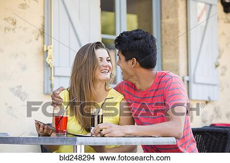 Couple reading menu and hugging at restaurant View Large Photo Image Picture - Couple reading menu and hugging at restaurant. Fotosearch