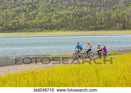Couple with son and daughter riding bicycles near lake View Large Photo Image Stock Image - Couple with son and daughter riding bicycles near lake. Fotosearch