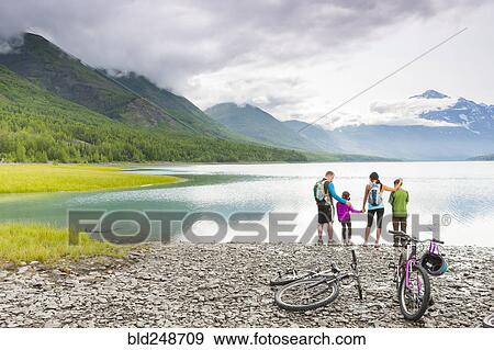 Couple with son and daughter riding bicycles near lake View Large Photo Image Stock Photo - Couple with son and daughter riding bicycles near lake. Fotosearch