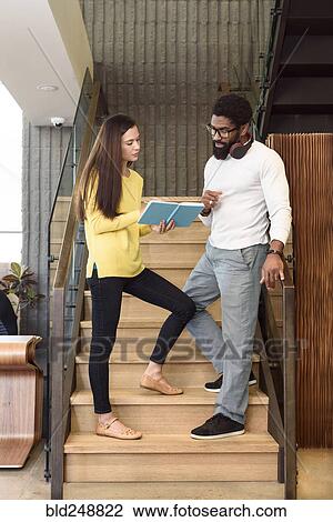 Stock Image - Creative business people talking on staircase. Fotosearch