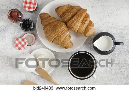 Stock Image - Croissants on plate with coffee and jam. Fotosearch