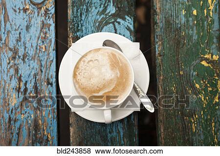 Stock Photo - Cup of coffee with foam on wooden table. Fotosearch