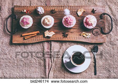 Picture - Cupcakes on ingredients on wooden tray with coffee. Fotosearch
