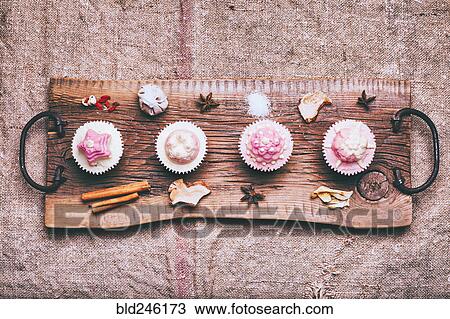 Stock Image - Cupcakes on ingredients on wooden tray. Fotosearch