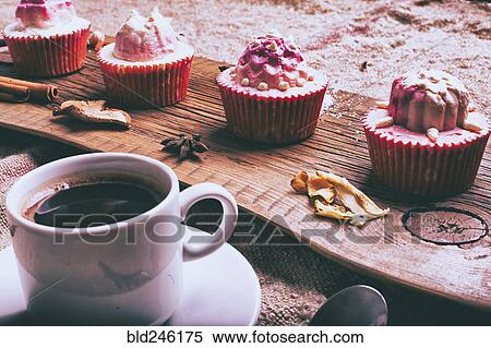 Stock Photography - Cupcakes on ingredients on wooden tray with coffee. Fotosearch