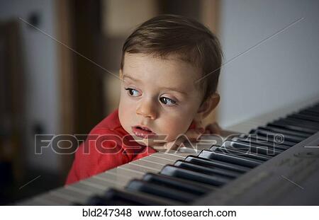 Curious boy leaning on piano View Large Photo Image Stock Photo - Curious boy leaning on piano. Fotosearch