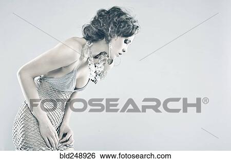 Stock Photograph - Curious Caucasian woman wearing sheer dress looking down. Fotosearch