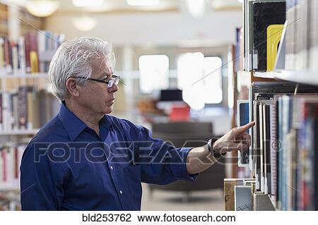Curious Hispanic man searching for book in library View Large Photo Image Stock Image - Curious Hispanic man searching for book in library. Fotosearch
