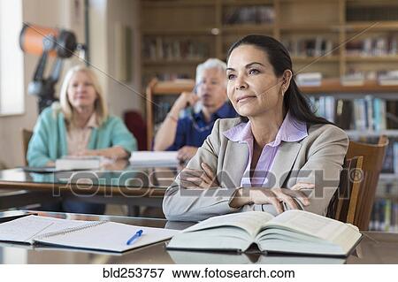 Stock Photo - Curious older woman listening in library. Fotosearch