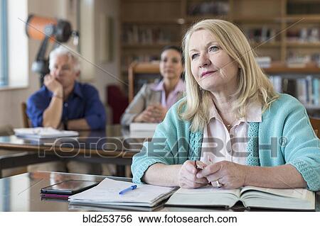 Stock Photograph - Curious older woman listening in library. Fotosearch