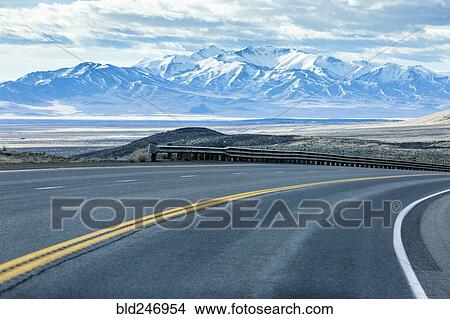 Curving street near mountain range View Large Photo Image Picture - Curving street near mountain range. Fotosearch