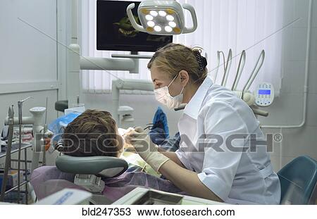 Stock Image - Dentist treating boy. Fotosearch