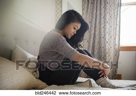 Depressed Mixed Race woman sitting on bed View Large Photo Image Stock Image - Depressed Mixed Race woman sitting on bed. Fotosearch