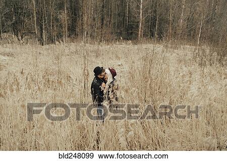 Distant Middle Eastern couple kissing in field View Large Photo Image Stock Photo - Distant Middle Eastern couple kissing in field. Fotosearch