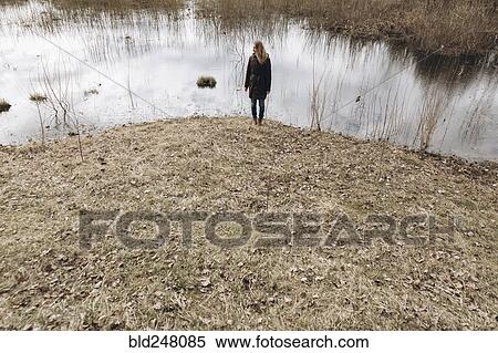 Distant Middle Eastern woman standing near pond View Large Photo Image Stock Photography - Distant Middle Eastern woman standing near pond. Fotosearch