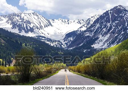 Distant people bicycling on road to mountain View Large Photo Image Stock Image - Distant people bicycling on road to mountain. Fotosearch
