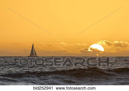 Distant sailboat in ocean at sunset View Large Photo Image Stock Image - Distant sailboat in ocean at sunset. Fotosearch