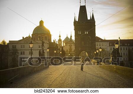 Picture - "Distant woman standing on bridge in Prague, Czech Republic". Fotosearch