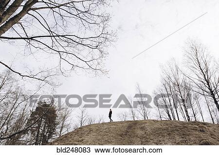 Distant woman standing on hill View Large Photo Image Stock Image - Distant woman standing on hill. Fotosearch