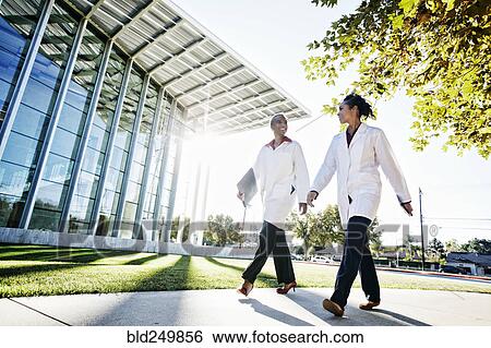Doctors walking and talking outdoors at hospital View Large Photo Image Stock Photograph - Doctors walking and talking outdoors at hospital. Fotosearch