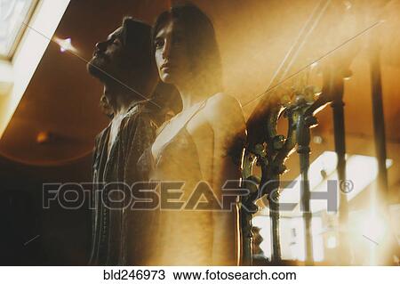 Stock Image - Double exposure of Caucasian couple and railing. Fotosearch