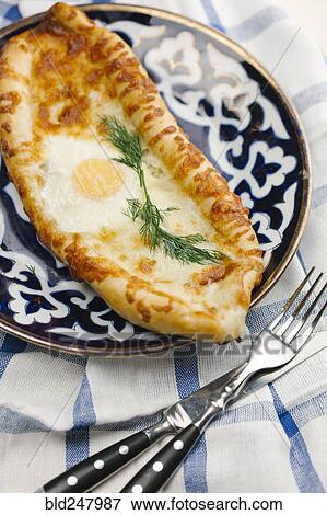Stock Photo - Egg and melted cheese on bread. Fotosearch