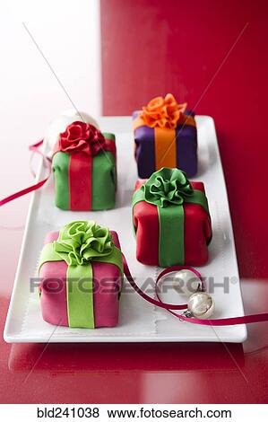 Stock Photo - Elegant cheesecake gifts on plate with ornaments and ribbon. Fotosearch
