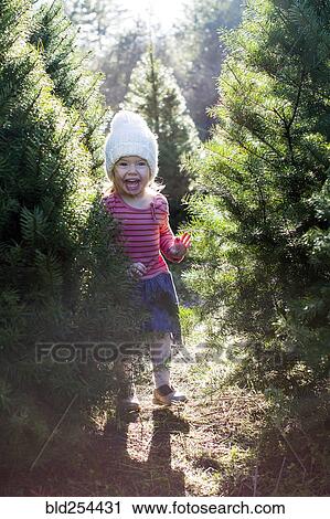 Stock Image - Excited Caucasian girl standing near trees. Fotosearch