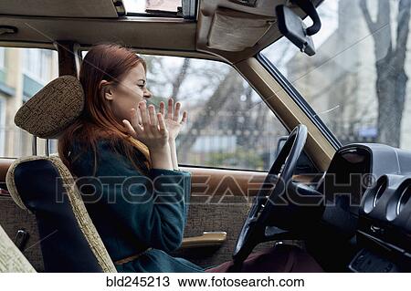 Stock Image - Excited Caucasian woman driving car. Fotosearch