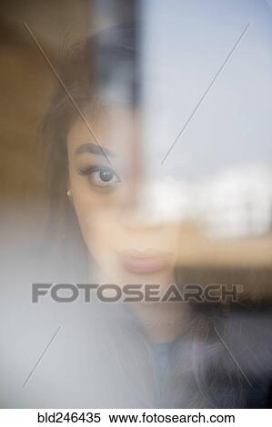 Face of serious Mixed Race woman behind window View Large Photo Image Stock Photography - Face of serious Mixed Race woman behind window. Fotosearch
