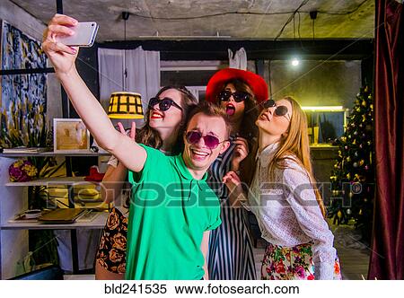 Fashionable Caucasian friends posing for cell phone selfie View Large Photo Image Stock Photography - Fashionable Caucasian friends posing for cell phone selfie. Fotosearch