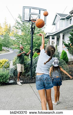 Father and daughters playing basketball in driveway View Large Photo Image Stock Image - Father and daughters playing basketball in driveway. Fotosearch