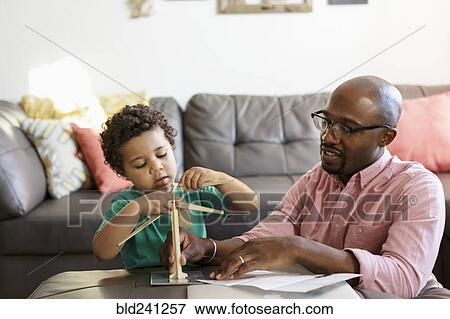 Father and son building model windmill in livingroom View Large Photo Image Stock Photo - Father and son building model windmill in livingroom. Fotosearch