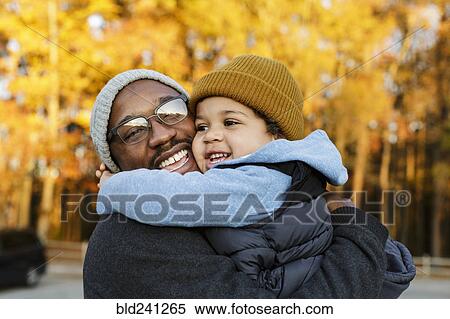 Stock Photography - Father and son hugging in park. Fotosearch