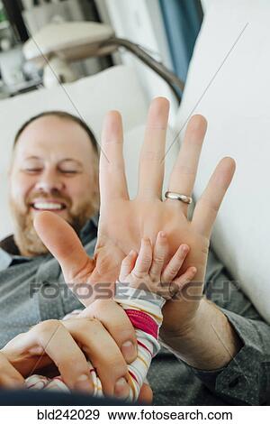 Father high-fiving baby daughter View Large Photo Image Stock Photo - Father high-fiving baby daughter. Fotosearch