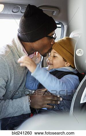 Father kissing son in car seat on forehead View Large Photo Image Stock Image - Father kissing son in car seat on forehead. Fotosearch