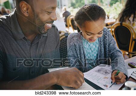 Stock Photo - Father watching daughter coloring with crayon in restaurant. Fotosearch