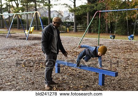 Father watching son jumping over playground beam View Large Photo Image Stock Photo - Father watching son jumping over playground beam. Fotosearch