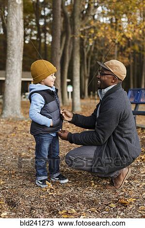 Father zipping vest for son in park View Large Photo Image Stock Image - Father zipping vest for son in park. Fotosearch