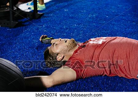 Fatigued Caucasian man laying on sports field View Large Photo Image Picture - Fatigued Caucasian man laying on sports field. Fotosearch