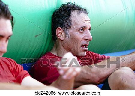 Stock Photograph - Fatigued Caucasian men resting outdoors. Fotosearch