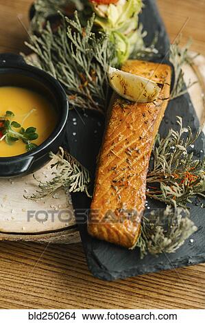 Picture - Fish with melted butter and lemon slice. Fotosearch