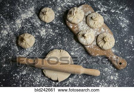 Stock Image - Flour on rolling pin and dough. Fotosearch