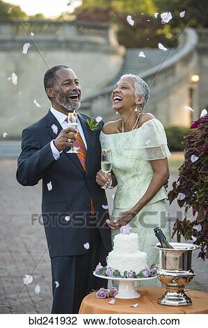 Stock Image - Flower petals falling on Black newlyweds. Fotosearch