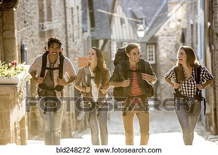 Stock Image - Friends backpacking in city. Fotosearch