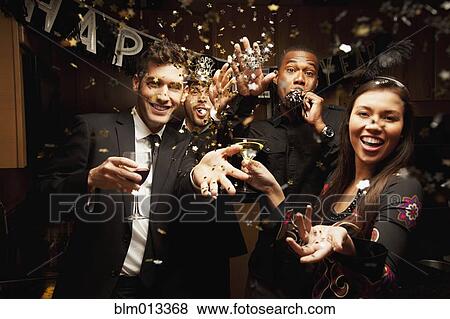 Stock Photo - Friends drinking in kitchen at New Year's Eve party. Fotosearch