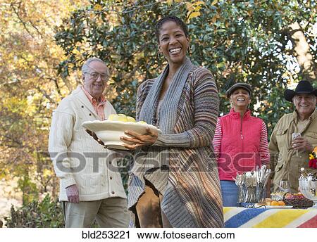 Friends enjoying food and drink outdoors View Large Photo Image Stock Image - Friends enjoying food and drink outdoors. Fotosearch