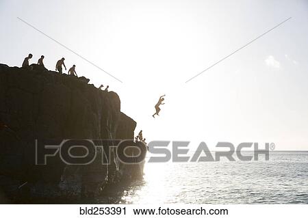 Friends jumping from cliff into ocean View Large Photo Image Stock Image - Friends jumping from cliff into ocean. Fotosearch