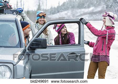 Friends laughing near car in winter View Large Photo Image Stock Image - Friends laughing near car in winter. Fotosearch